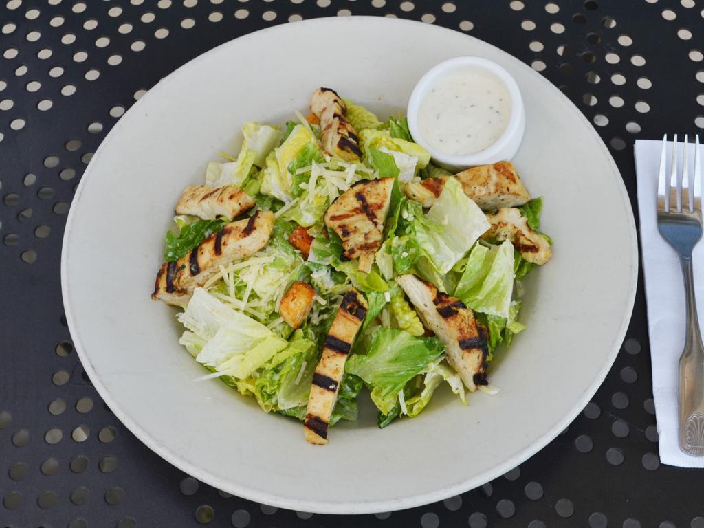 Caesar Salad · Chopped romaine hearts tossed with croutons and Caesar dressing topped with shaved Parmesan cheese.