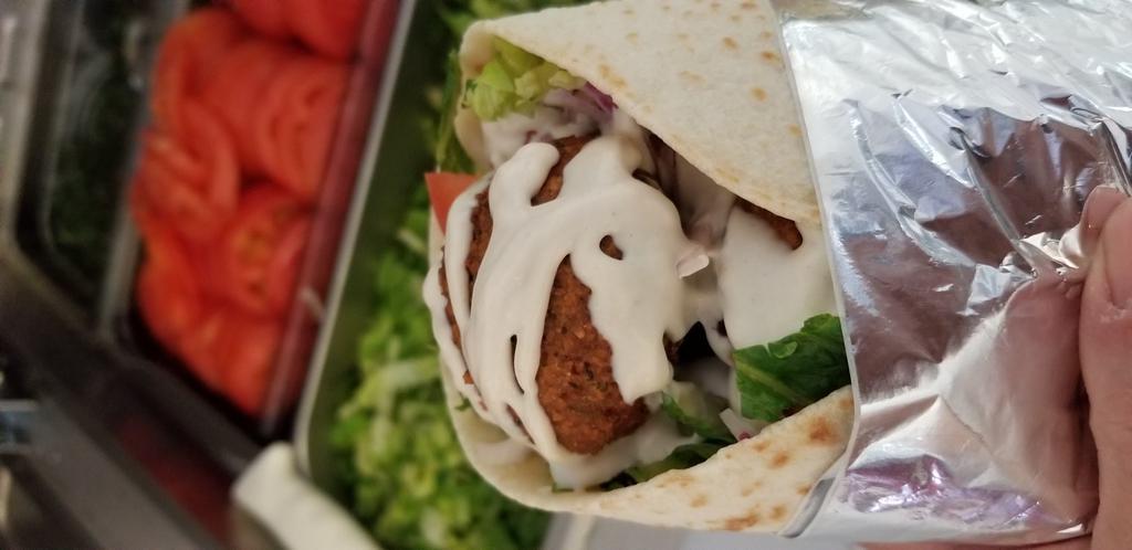 Falafel Wrap  · Falafel served with hummus, lettuce, tomato, onion and tahini sauce. Vegetarian. wrapped in in house made pita   pita