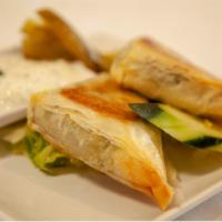 Spanakopita with Tzatziki Sauce · Spinach and feta cheese wrapped in filo dough and baked.