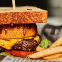 The Texan Burger · Grilled to order and topped with lettuce, tomato, red onion, fried pickles, anonion ring and...