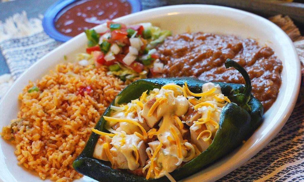 Chicken Stuffed Poblano  · Poblano pepper stuffed with fajita chicken, topped with cilantro cream sauce and mixed cheese and garnished with lettuce and pico de gallo. Served with Mexican rice and refried beans.