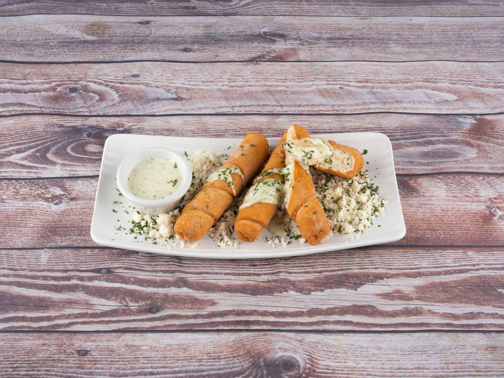 Venezuelan Tequenos · Large, lightly breaded cheese sticks topped off with cilantro cream and queso fresco.