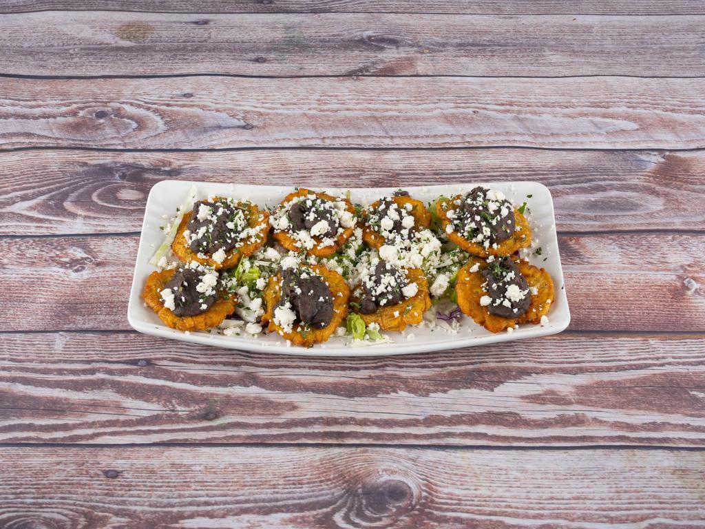Tostones · Fried plantains flattened served with refried beans and topped off with queso fresco.