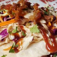 Naked Chicken Taco · Naked Chicken, crispy onions, crunchy slaw, fresh cut cilantro, bacon crumbles, BBQ sauce on...