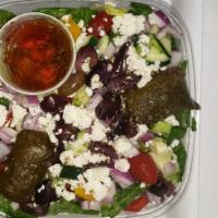 Greek Salad · Crisp lettuce, feta cheese, stuffed grape leaves, tomatoes, and Kalamata olives. Served with...