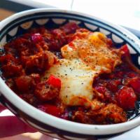 Shakshuka  · Sauteed tomatoes, onions, red peppers, garlic, cumin & poached eggs served with warm Pita br...