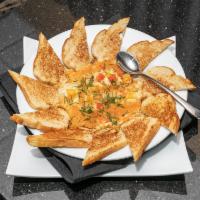 Creamy Crab Dip · A creamy blend of cheese, herbs, artichokes, and crab. Topped with diced bell peppers. Serve...
