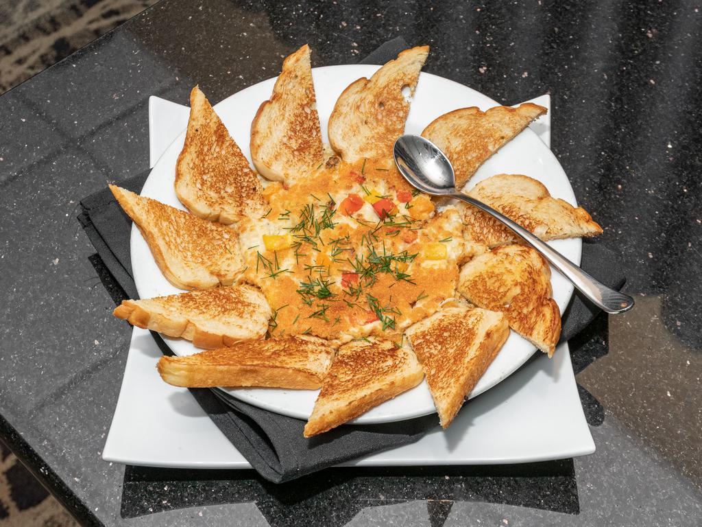 Creamy Crab Dip · A creamy blend of cheese, herbs, artichokes, and crab. Topped with diced bell peppers. Served with toasted garlic bread. Make it gluten free upon request.