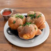 Garlic Knots · Tossed in roasted garlic butter, fried parsley, shaved Parmesan and Romano cheese with marin...
