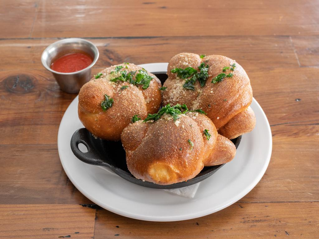 Garlic Knots · Tossed in roasted garlic butter, fried parsley, shaved Parmesan and Romano cheese with marinara. Substitute vegan Parmesan upon request.