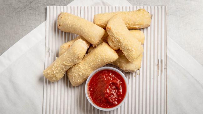Everything Inn Stix · Brushed with garlic butter, topped with everything seasoning and served with a side of pizza sauce.