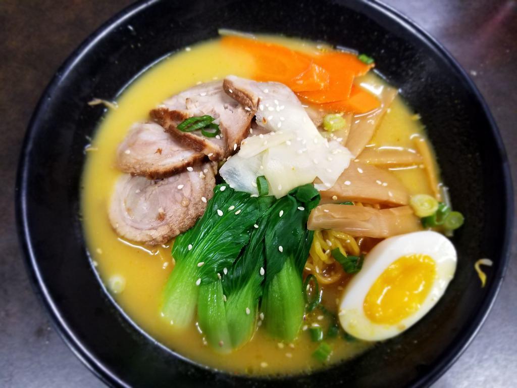 Yellow Curry Ramen · Chashu pork in yellow curry, egg, bok choy, pickled bamboo, fish cake, green onion, carrot, bean sprouts, sesame on top.