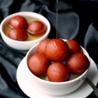 Gulab Jamun · Traditional deep-fried milk pastry served in rosewater honey syrup with a sprinkle of crushe...
