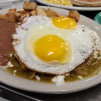 Chilaquiles with Eggs · Tortilla chips with sauce of your choice, queso fresco, sour cream and two eggs on top, serv...