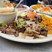 Carne Asada Plate · Carne asada mixed with grilled onions and bell pepers, served with rice, refried beans and 2...