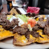 Nachos Supreme · Nacho chips covered with melted cheddar cheese and refried beans, topped with meat of your c...