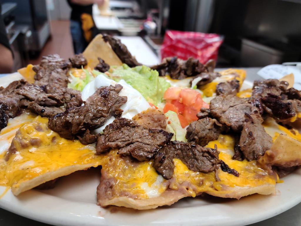 Nachos Supreme · Nacho chips covered with melted cheddar cheese and refried beans, topped with meat of your choice and served with sour cream, guacamole, and jalapenos on the side