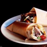 Beef Shawarma Sandwich · Prime top round, grilled tomato, onion, parsley, sumac, cucumber pickles, tahini, topped wit...
