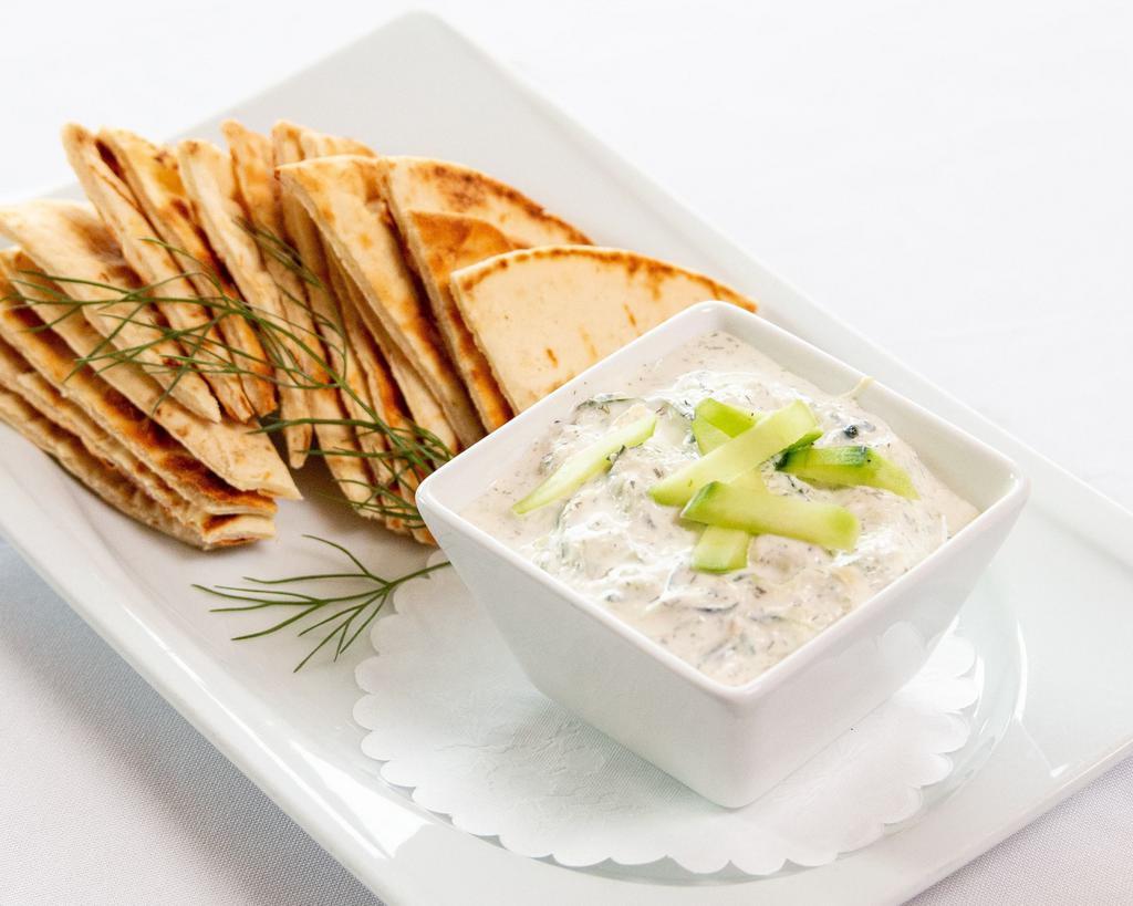Tzatziki + Pita · fresh Greek yogurt, dill, grated cucumber, lemon + garlic dip served with warm pita wedges