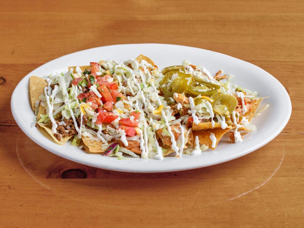 Nachos Supreme · Ground beef ,shredded chicken and beans on a bed of chips covered with lettuce, sour cream, tomatoes, jalapenos topped with cheese dip.