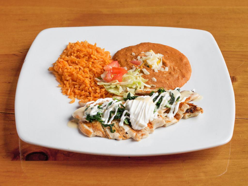 Pollo con Crema · Strips of grilled chicken sauteed with spinach and covered with cheese sauce served with rice and choice of beans.