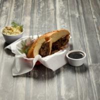 French Dip · Thin slices of roast beef piled high on a French roll. Served with au-jus or BBQ sauce and c...