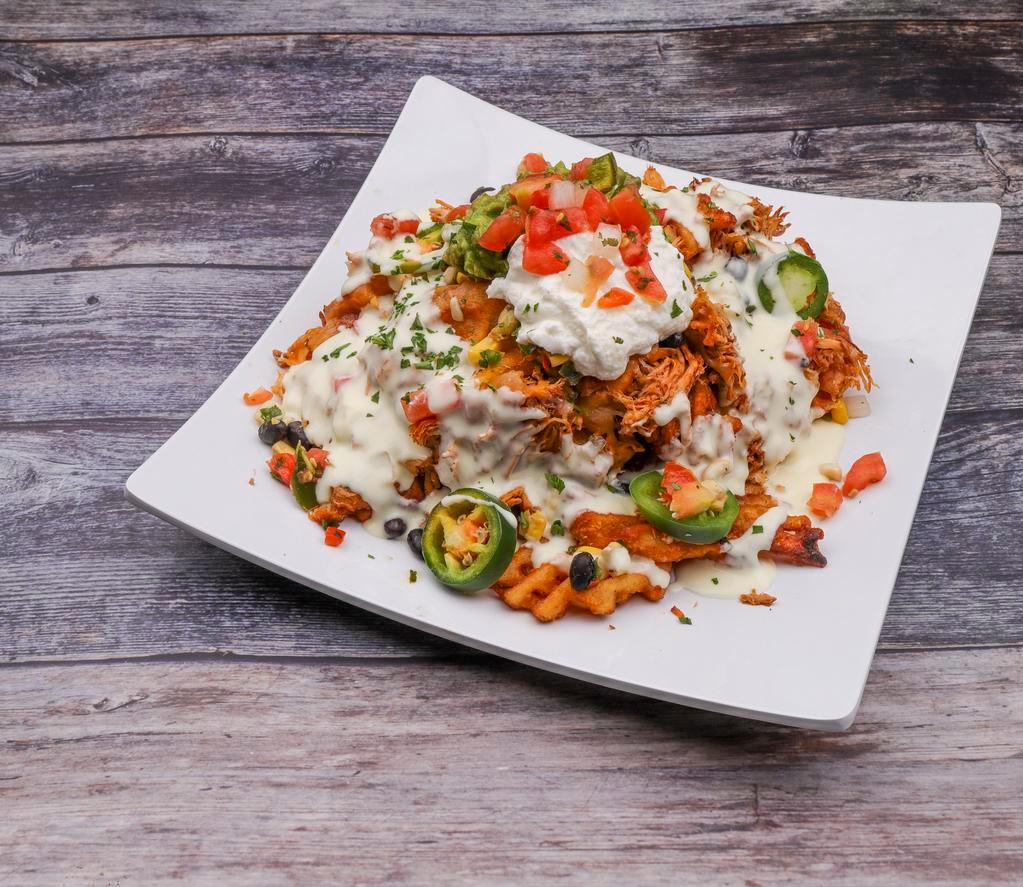 Waffle Fry Nachos · Smothered with white cheddar sauce and shredded cheeses, topped with house smoked chicken and finished with black bean corn salsa, fresh jalapenos, pico, guacamole and sour cream.