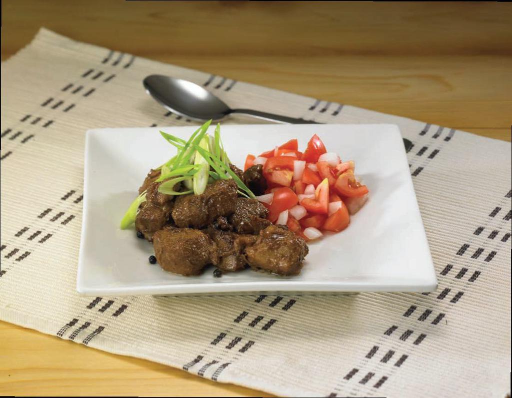 Pinatuyoung Pork Adobo (Marinated braised pork adobo) · Marinated pork chunks braised in vinegar and soy sauce reduction.  Made flavorful with garlic, bay leaf, and whole peppercorn.  Garnished with green onions and served with diced tomatoes and onions. 