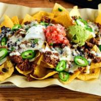 East Village Nachos · Loaded with queso, black beans, sour cream, pico de gallo, jalapenos, house guac, and your c...