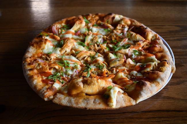 Buffalo Wing Pizza · Tender shredded chicken, mozzarella, bleu cheese, and red & green onion are perfectly melded with authentic Buffalo wing sauce to create this signature pizza.