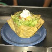 Tostada Lito · A flour tortilla basket filled with shredded beef or chicken and beans. Topped with crisp le...
