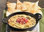 Cheesy Artichoke Dip · Three-cheese artichoke dip is served hot, topped with pico de gallo and melted parmesan cheese. Served with crispy tortilla wedges seasoned with Cajun spices.
