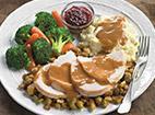 Freshly Roasted Turkey Dinner · Roasted Turkey Dinner MC Signature Item 
Served over our apple-sage stuffing and topped with homemade giblet gravy. Served with fresh mashed potatoes, tangy cranberry sauce and fresh seasonal vegetables.