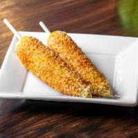 Elote Preparado · Fresh elote (corn) on a cob, prepared with mayonnaise, queso fresco, and topped with chile p...