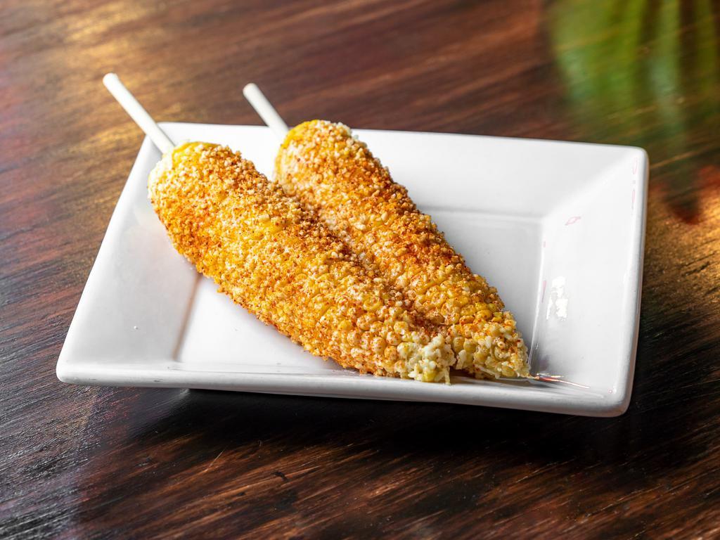 Elote Preparado · Fresh elote (corn) on a cob, prepared with mayonnaise, queso fresco, and topped with chile power!