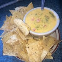 Chile con Queso · Chile and cheese sauce served with tostada chips. Vegetarian. Gluten free.