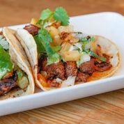 Tacos Al Pastor · Two Adobo marinated pork tacos, chopped white onion, cilantro, and charred pineapple. Served...