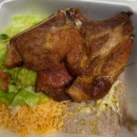Chuleta de Puerco · 2 pork chops smothered with green chili. Served with lettuce tomatoes and grilled jalapeno p...