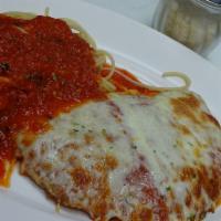 Chicken Parmigiana · Breaded and baked with baked tomato and mozzarella. Served with pasta in tomato sauce.