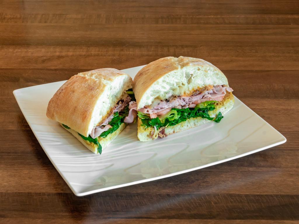 Ham Ciabatta · Smoked ham, salami, prosciutto with tomato, roasted onions, forest greens, cheddar cheese, Swiss cheese, and whole grain mustard.