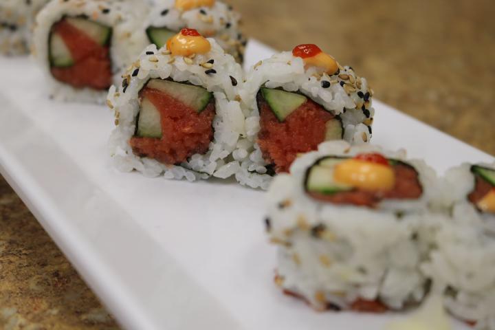 Spicy Tuna Roll · Nori (dried seaweed), sushi rice, sesame seed, spicy tuna, and cucumber. Topped with spicy mayo and sriracha. (8pcs)