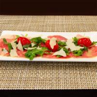 Beef Carpaccio Salad ·  with filet  mignion row Arugula,  extra virgin olive oil, and lemon dressing.