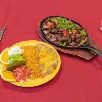 Beef Fajitas · Tender strips of our marinated flank steak, sauteed with bell peppers, onions, and tomatoes....