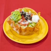Taco Salad · Thin layer of beans, the meat of your choice, shredded lettuce, queso fresco, tomatoes, sour...
