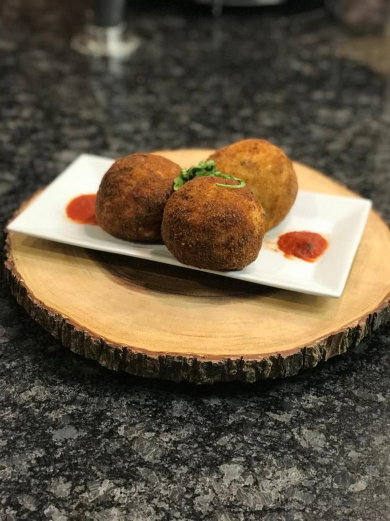 Rice Ball · Fried, breaded rice stuffed with peas and ground beef.