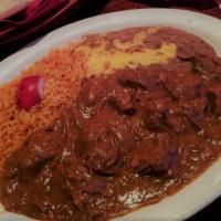 Chile Colorado (Platillos) · Chunks of beef braised in our famous mole' sauce. Served with rice beans and tortillas.