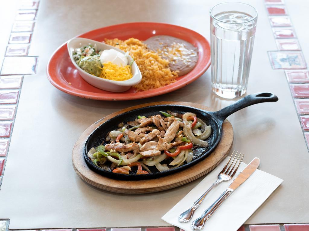 Fajitas · Marinated in our secret sauce, then delivered sizzling hot over a bed of sauteed
onions and green peppers. Served with rice, choice of pinto or black beans, pico de
gallo, cheese, lettuce, sour cream, guacamole and tortillas.