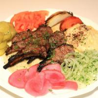 Ribs · Lamb ribs grilled on fire, served with onions and tomatoes, pita bread, hummus, pickles 7and...