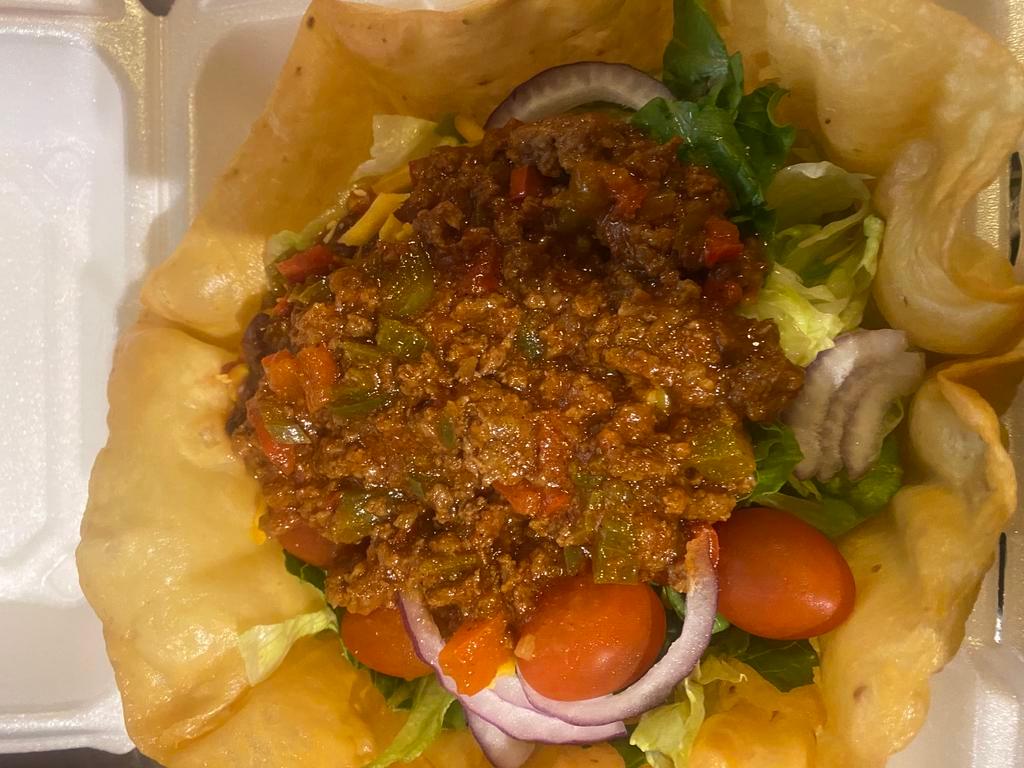 Taco Salad · A taco shell with seasoned ground beef or chicken, red onions, lettuce, tomatoes, black olives, and cheddar cheese. Topped with our own hopi corn and black bean salsa. Served with sour cream jalapenos on the side.