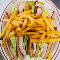 Traditional Club Sandwich · Layers of turkey, ham, bacon, lettuce, tomato, and Swiss cheese between three slices of toast.